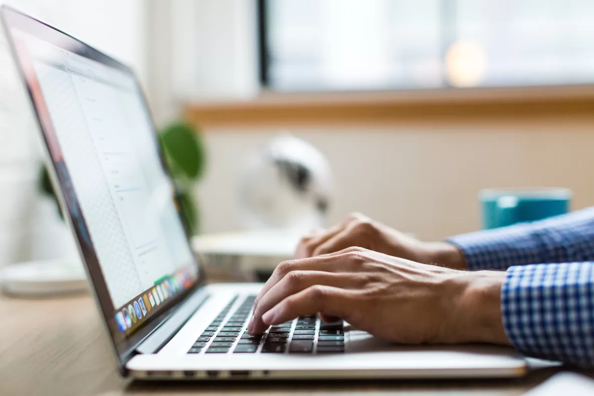 person typing on a laptop with close up on hands