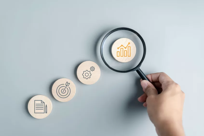 magnifying glass over a wooden disk of a chart